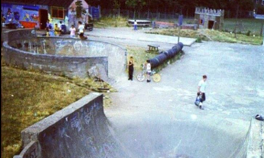 Local skatepark in the early years, kids hanging out around a concrete bowl